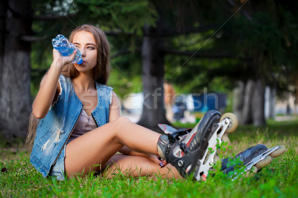 girl sitting on the grass and drinking water Stock photo © chesterf