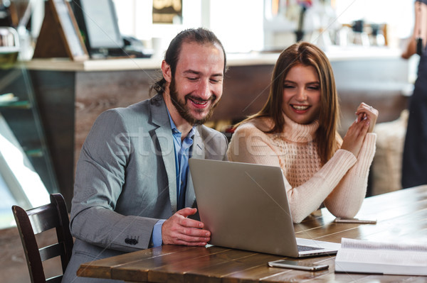 Stock photo: couple in a cafe looking to laptop