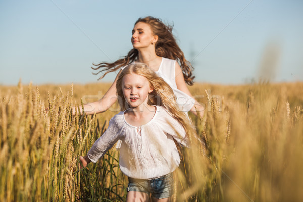 two sisters running on wheat filed Stock photo © chesterf