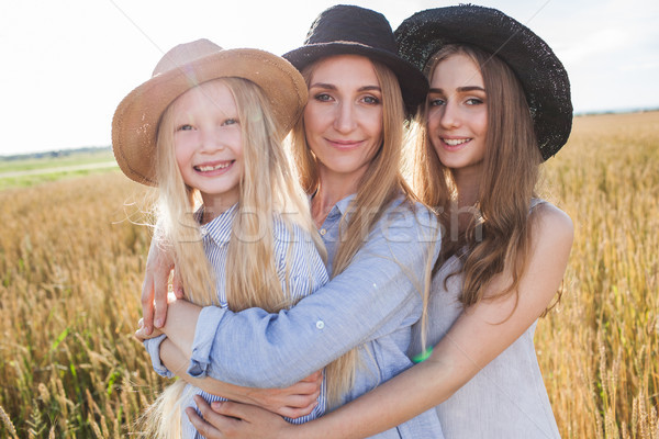 beautiful young mother and her daughters at the wheat field Stock photo © chesterf