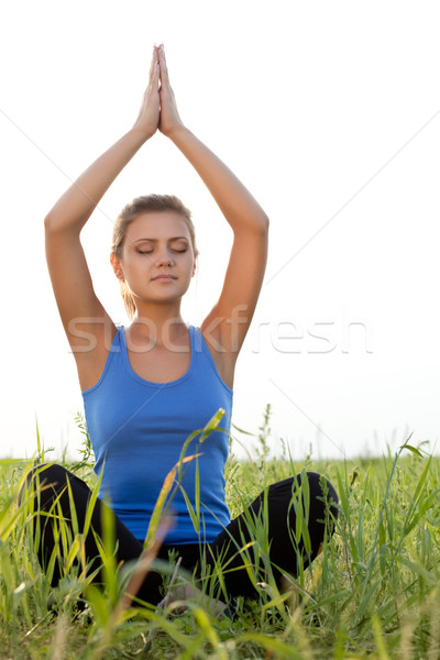 Stock photo: woman on filed in lotus pose