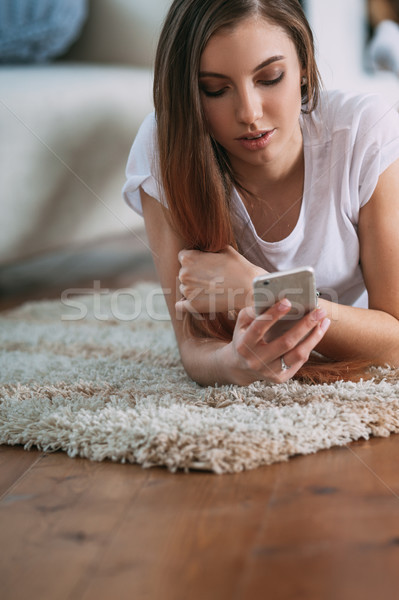 Fiatal nő okostelefon szőnyeg otthon kommunikáció kanapé Stock fotó © chesterf
