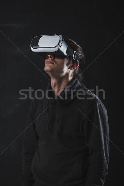 man standing in virtual reality helmet before dark background Stock photo © chesterf