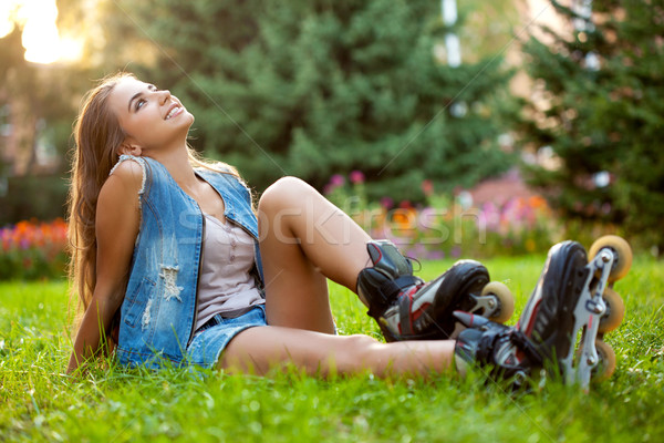 girl wearing roller skates sitting on grass Stock photo © chesterf