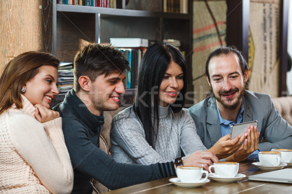 Group of friends with coffee and looking at smartphone Stock photo © chesterf
