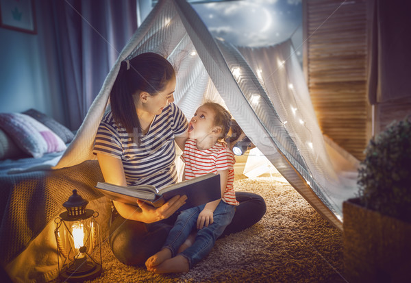 Mom and child reading a book Stock photo © choreograph