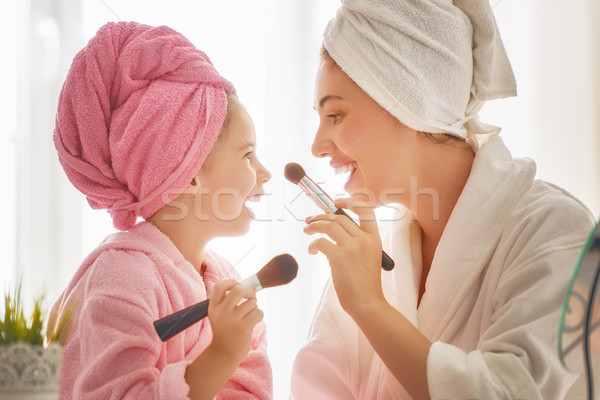 Mother and daughter are doing make up Stock photo © choreograph