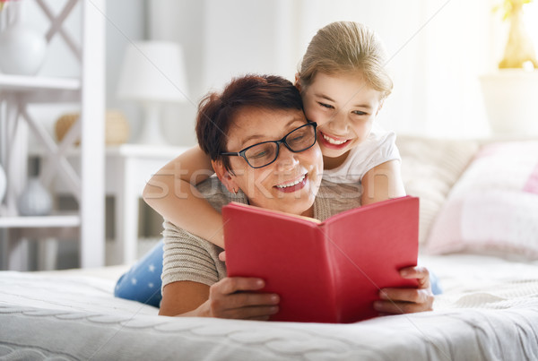 Grandmother reading a book to granddaughter Stock photo © choreograph