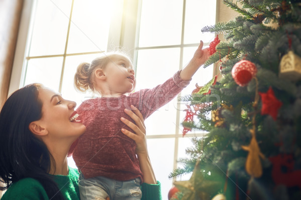 Mom and daughter decorate Christmas tree Stock photo © choreograph