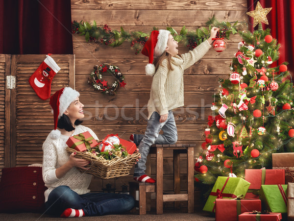 Stock photo: Mom and daughter decorate the Christmas tree.