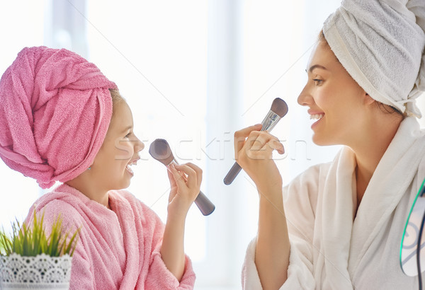 Mother and daughter are doing make up Stock photo © choreograph