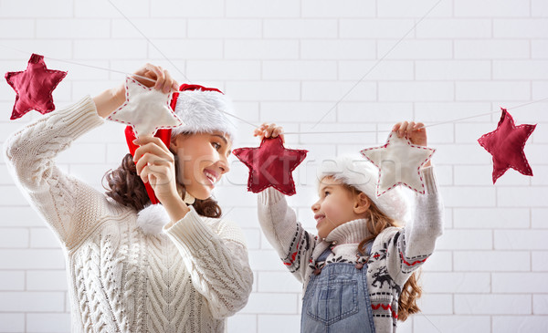mother and daughter hang a garland Stock photo © choreograph