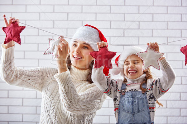 mother and daughter hang a garland Stock photo © choreograph