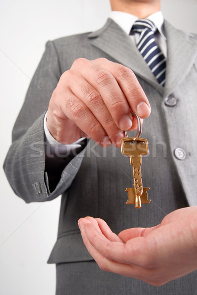 Businessman handing a key  Stock photo © cienpies