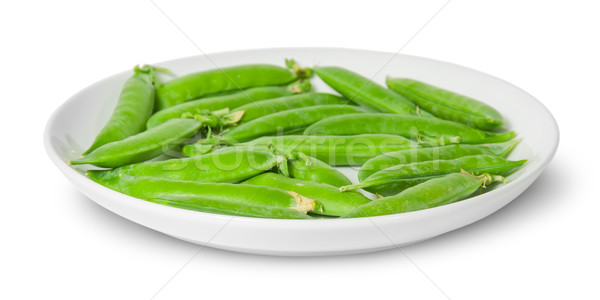 Stock photo: In front several pods of peas on a white plate