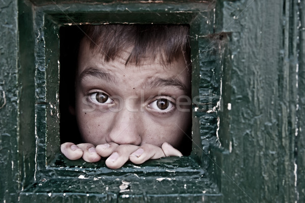 Stock photo: Prisoner face looks out through the jail window