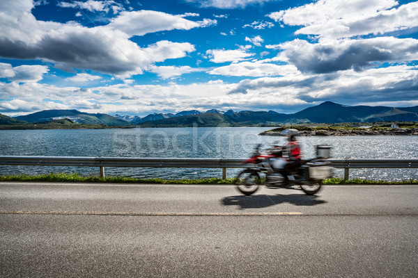 Biker rides a road with Atlantic Ocean Road in Norway. Stock photo © cookelma