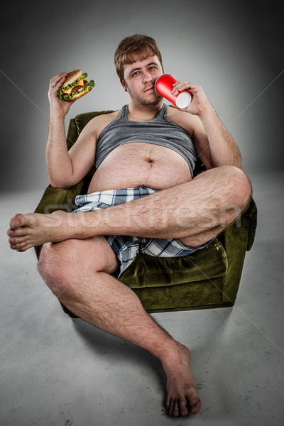 Vet man eten hamburger fauteuil stijl Stockfoto © cookelma