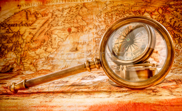 Vintage magnifying glass lies on an ancient world map Stock photo © cookelma
