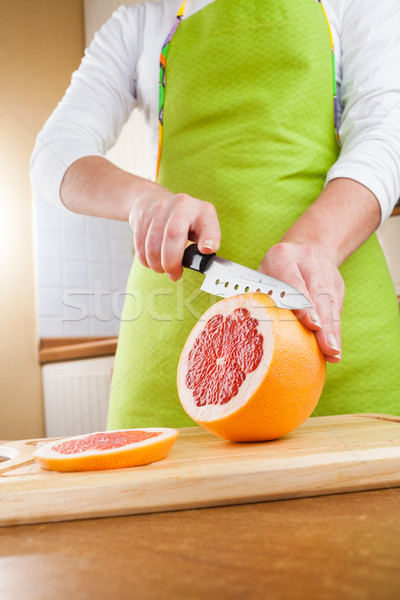 Stock photo: Woman's hands cutting grapefruit