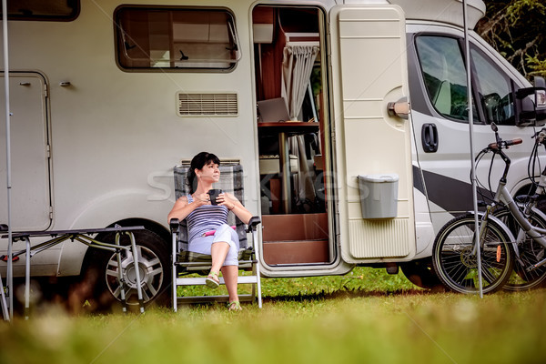Woman is standing with a mug of coffee near the camper RV. Stock photo © cookelma