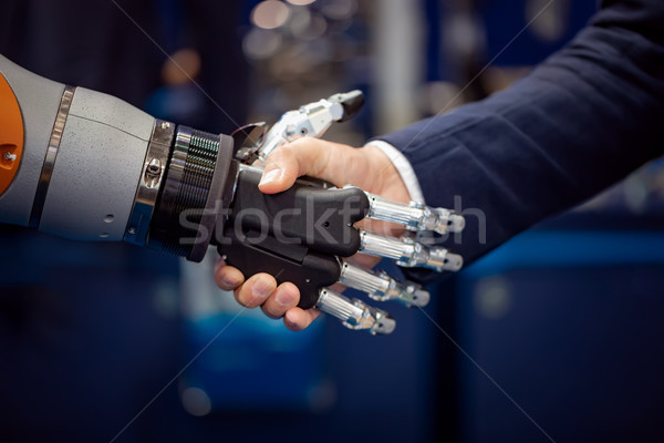 Mano imprenditore stringe la mano android robot umani Foto d'archivio © cookelma