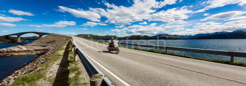 Biker rides a road with Atlantic Ocean Road in Norway. Stock photo © cookelma