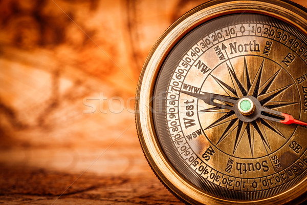 Vintage compass lies on an ancient world map. Stock photo © cookelma