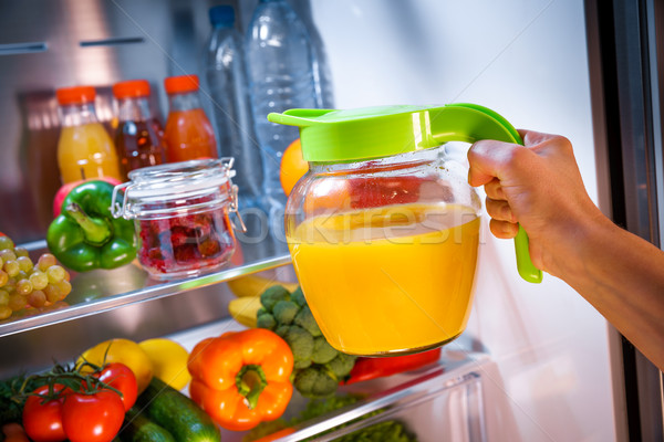 Kobieta sok pomarańczowy otwarte lodówce strony zdrowia Zdjęcia stock © cookelma