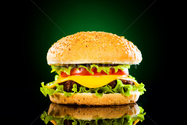 Tasty hamburger and french fries on a dark Stock photo © cookelma