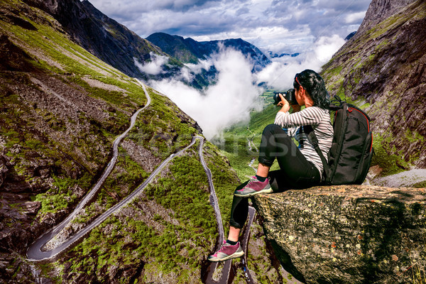 Nature photographer tourist with camera shoots while standing on Stock photo © cookelma