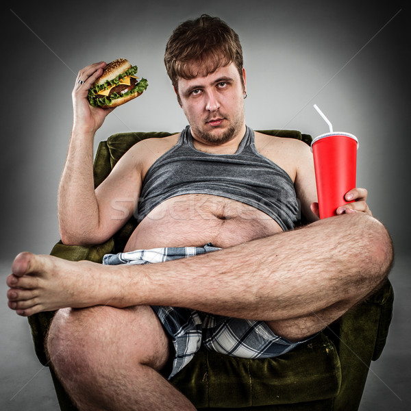 Vet man eten hamburger fauteuil stijl Stockfoto © cookelma