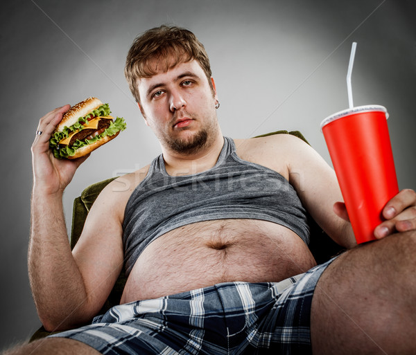 Uomo grasso mangiare hamburger poltrona stile Foto d'archivio © cookelma