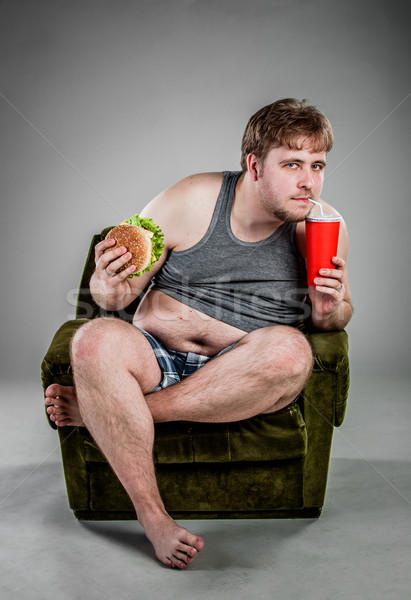 Gordo comer hamburguesa sentado sillón alimentos Foto stock © cookelma