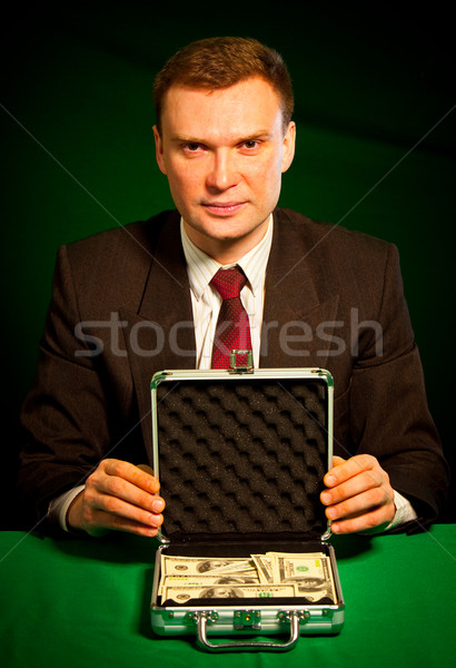 Stock photo: man's hand holds a suitcase with dollars