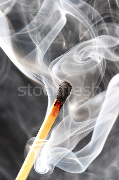 Photo of a burning match in a smoke on a black background Stock photo © cookelma