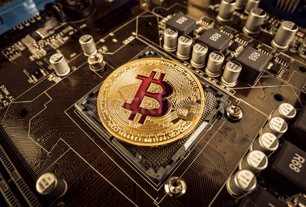 Gold Bit Coin BTC coins on the motherboard. Bitcoin is a worldwi Stock photo © cookelma