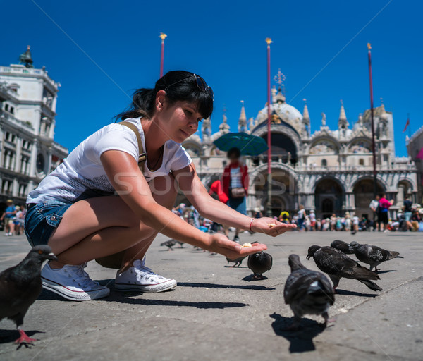 Woman tourist feeding pigeons in the square - St. Marks Square - Stock photo © cookelma