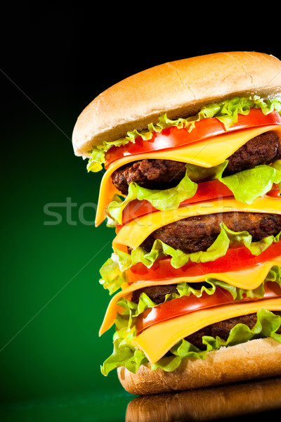 Stock photo: Tasty and appetizing hamburger on a darkly green