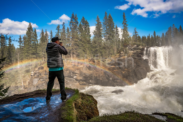 Nature photographer tourist with camera shoots while standing Ri Stock photo © cookelma