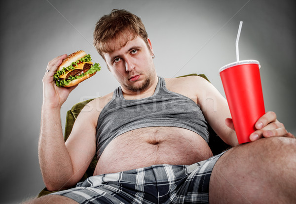 Gordo comer hamburguesa sentado sillón estilo Foto stock © cookelma