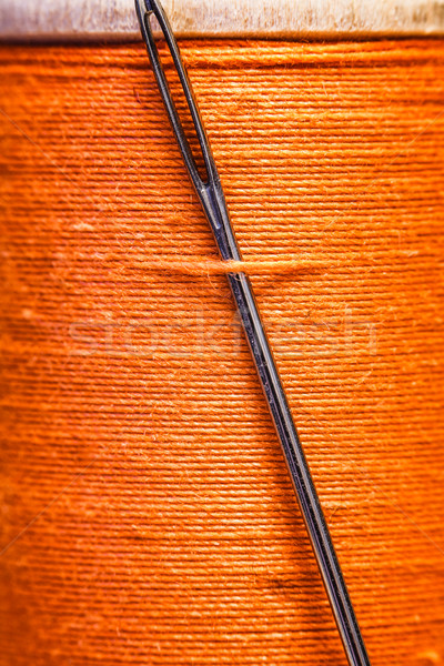 Spool of yellow thread with a needle stuck in it. Stock photo © cookelma