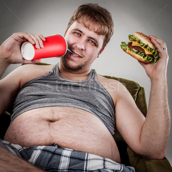 Vet man eten hamburger fauteuil stijl Stockfoto © cookelma