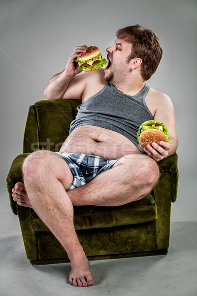 Fat man eating hamburger Stock photo © cookelma