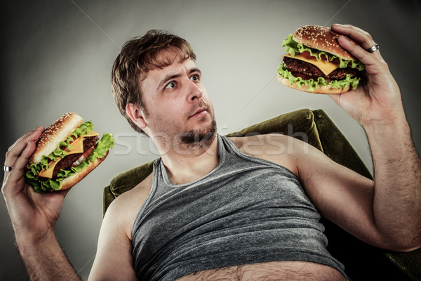 Vet man eten hamburger fauteuil stijl Stockfoto © cookelma