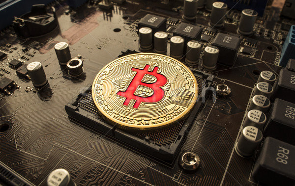 Stock photo: Gold Bit Coin BTC coins on the motherboard. Bitcoin is a worldwi