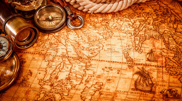 Stock photo: Vintage magnifying glass lies on an ancient world map