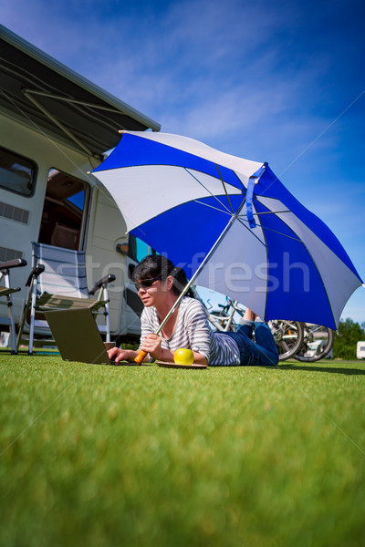 Woman on the grass, looking at the laptop under umbrella near th Stock photo © cookelma