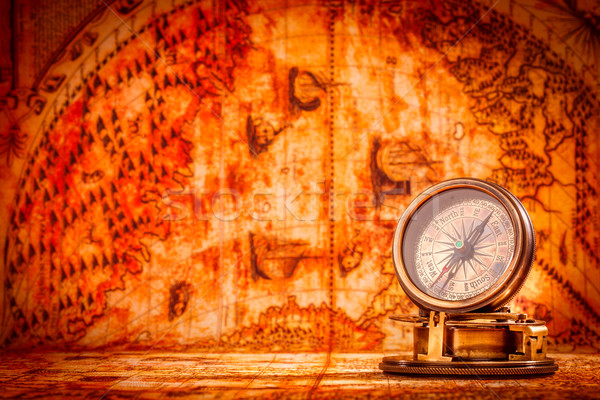 Vintage compass lies on an ancient world map. Stock photo © cookelma