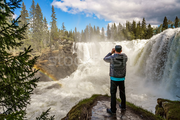 Nature photographer tourist with camera shoots while standing Ri Stock photo © cookelma